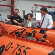 Chris Hooper shows Princess Anne and her husband Vice Admiral Sir Tim Laurence part of the process that goes into making a lifeboat, in East Cowes, in 2018
