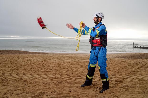 Isle of Wight County Press: HM Coastguard Coastal Operations Area Commander Tom Wright casts a throwline on Southbourne beach in Dorset (PA)