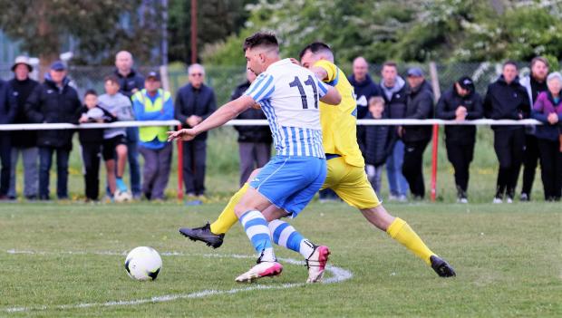 Isle of Wight County Press: Cowes Sports striker Ji Nash (in blue) gave Ryan Hughes of Newport a huge test in the first half. Photo; Barbara Close