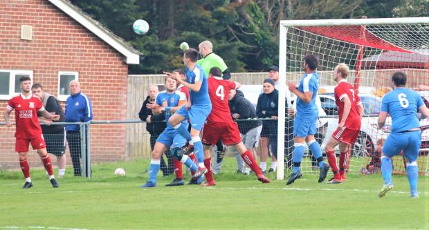 Isle of Wight County Press: W&B keeper Kev Mitchell punches decisively during a Shanklin attack.